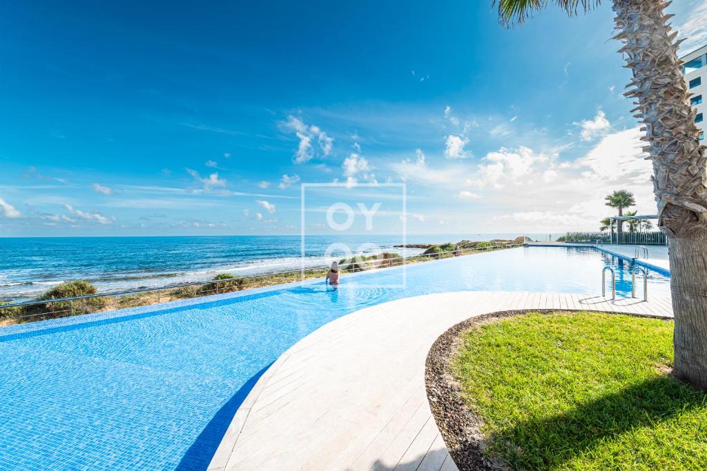 Punta Prima Apartment | Beachfront Bliss apt, with heated pool, by OYOOSTAYS